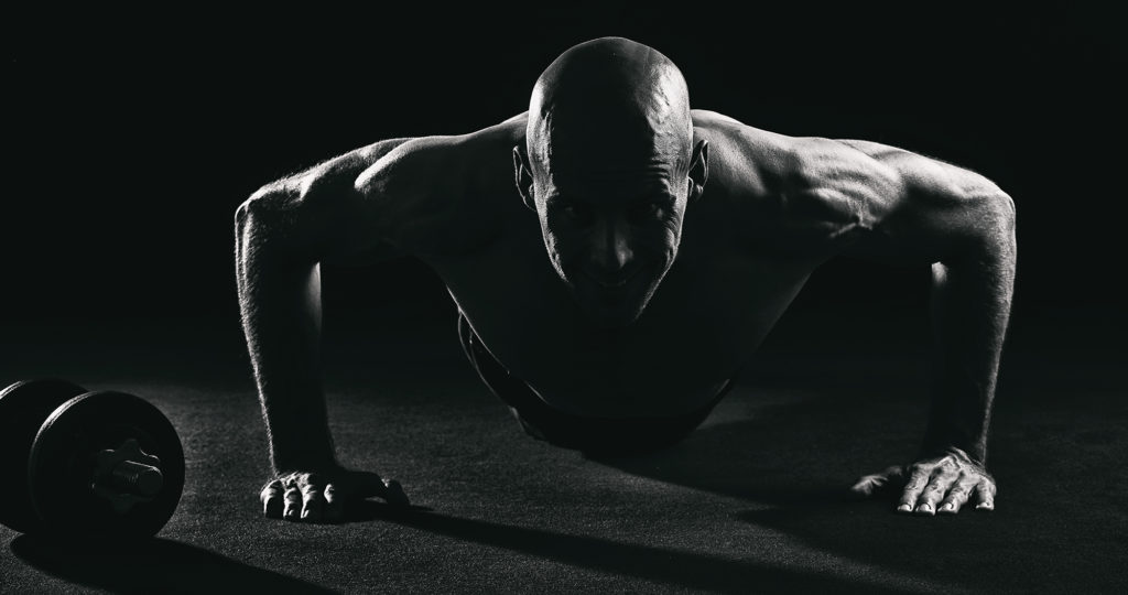 Kraftvolles Aktfoto eines Mannes von Sarah Reuther, das Fitness und Disziplin in der Aktfotografie eindrucksvoll darstellt.