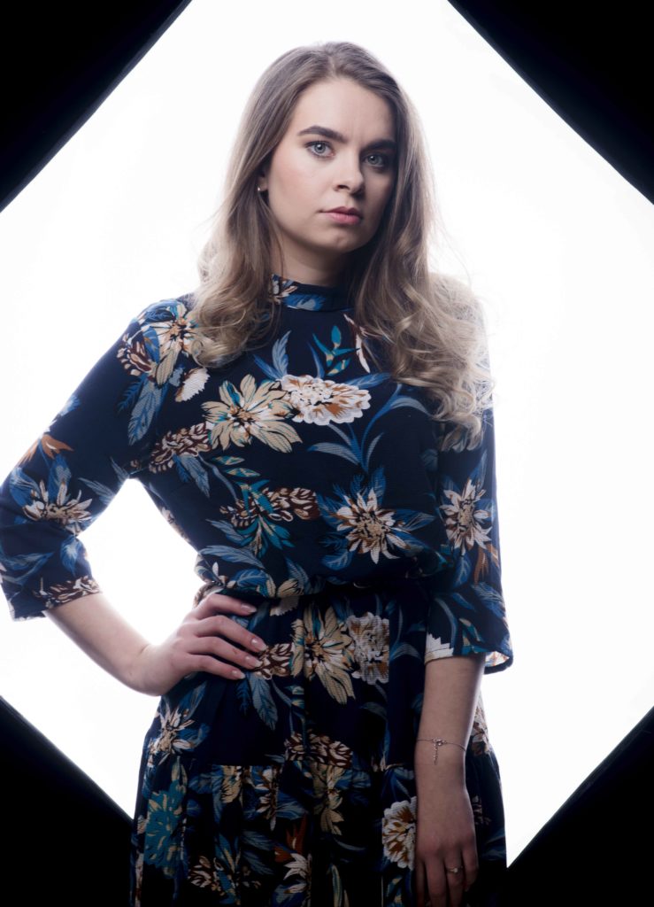 Portrait einer Frau in einem bunten Kleid.