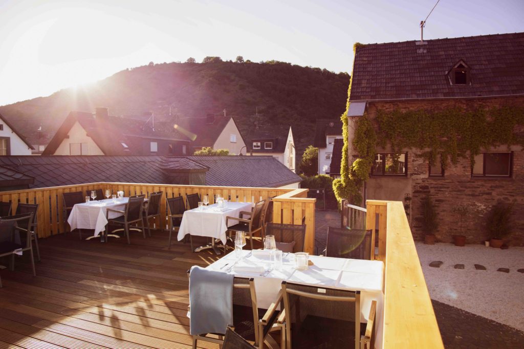 Foto der Terrasse bei Sonnenuntergang, die eine malerische Aussicht und eine entspannte Atmosphäre mit warmen Lichttönen bietet.