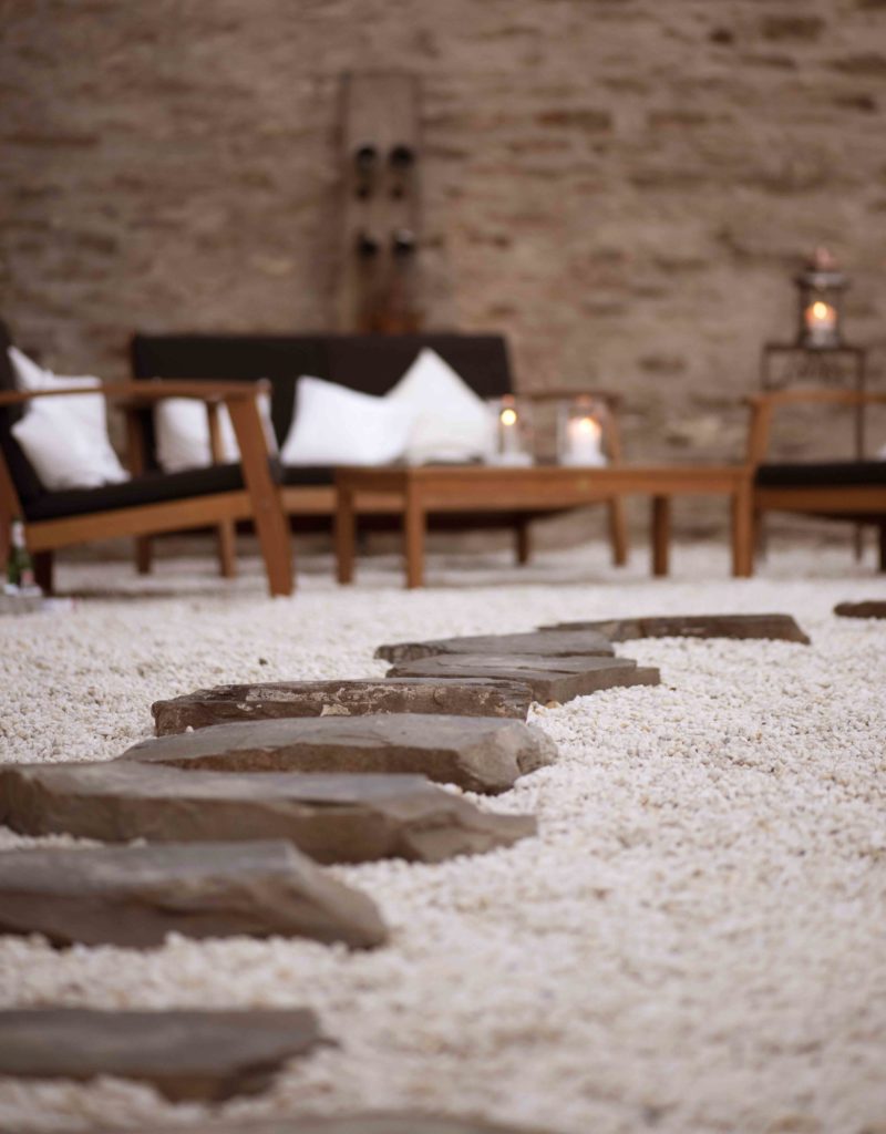 Detailaufnahme des Innenhofs des Hotels Halferschenke, der eine einladende Atmosphäre mit Sitzgelegenheiten und Pflanzen präsentiert.