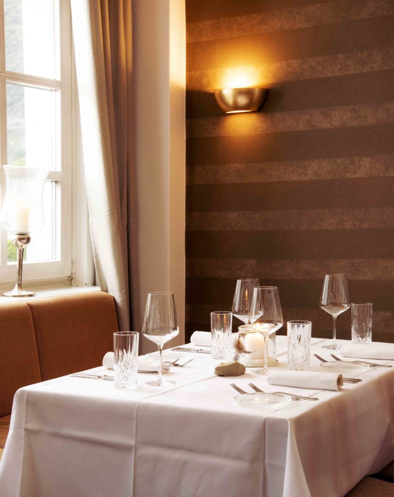 Foto eines gedeckten Tisches im Restaurant Halferschenke, der elegant mit Geschirr, Besteck und Dekoration für die Gäste vorbereitet ist.