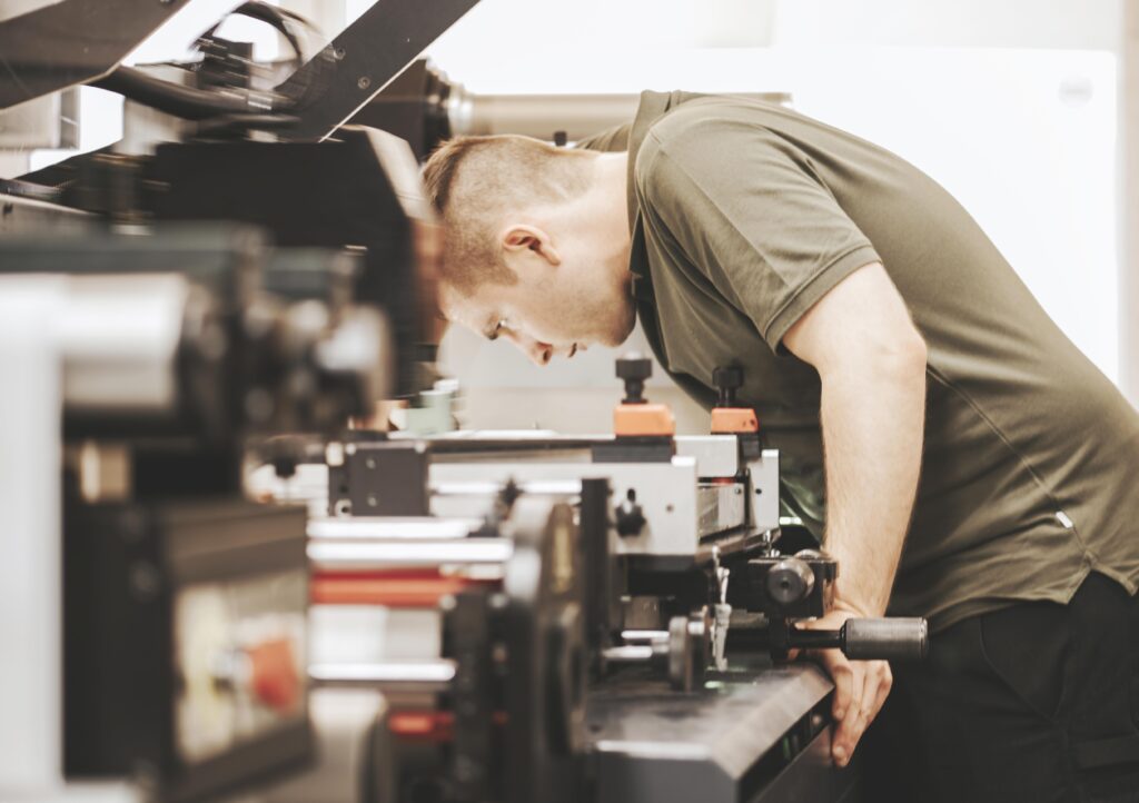 Arbeiter an der Etikettiermaschine, der den Etikettierungsprozess überwacht.