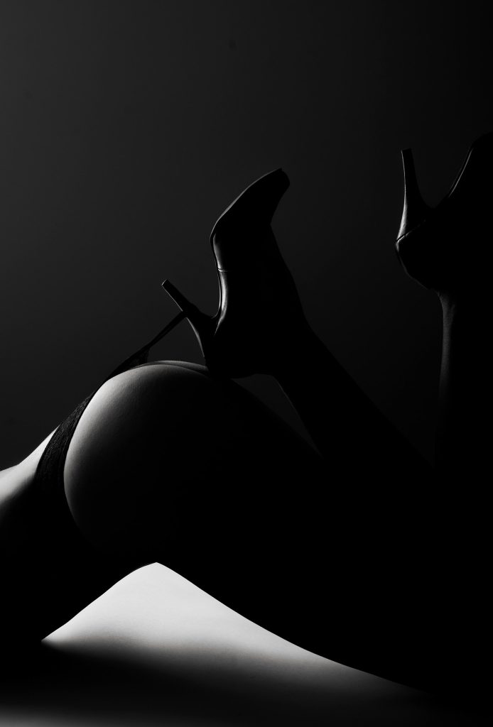 Elegantes Aktfoto einer Frau in High Heels von Sarah Reuther, das die Kurven und Eleganz in der Dessousfotografie betont.