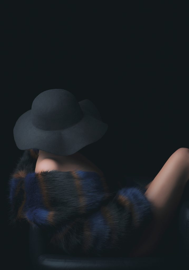 Geheimnisvolles Portrait einer Frau in Pelz und Hut von Sarah Reuther, ideal für stilvolle Boudoirfotografie und Dessous Shooting.