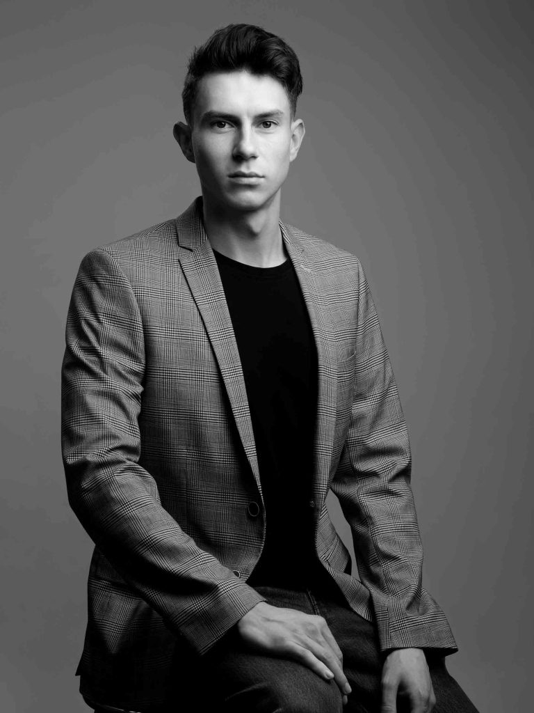 Portrait eines Mannes in Schwarz-Weiß, das seine Charakterzüge und Ausstrahlung eindrucksvoll zur Geltung bringt, eingefangen im künstlerischen und stilvollen Ansatz von Fotostudio Reuther. Bewerbungsfotografie von Fotostudio Reuther.