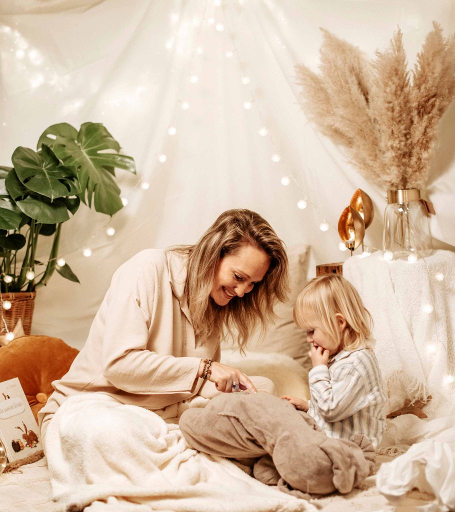 Zärtliches Familienportrait vom Fotostudio Reuther, das eine Familie mit Baby im Studio vor einem weißen Hintergrund zeigt.