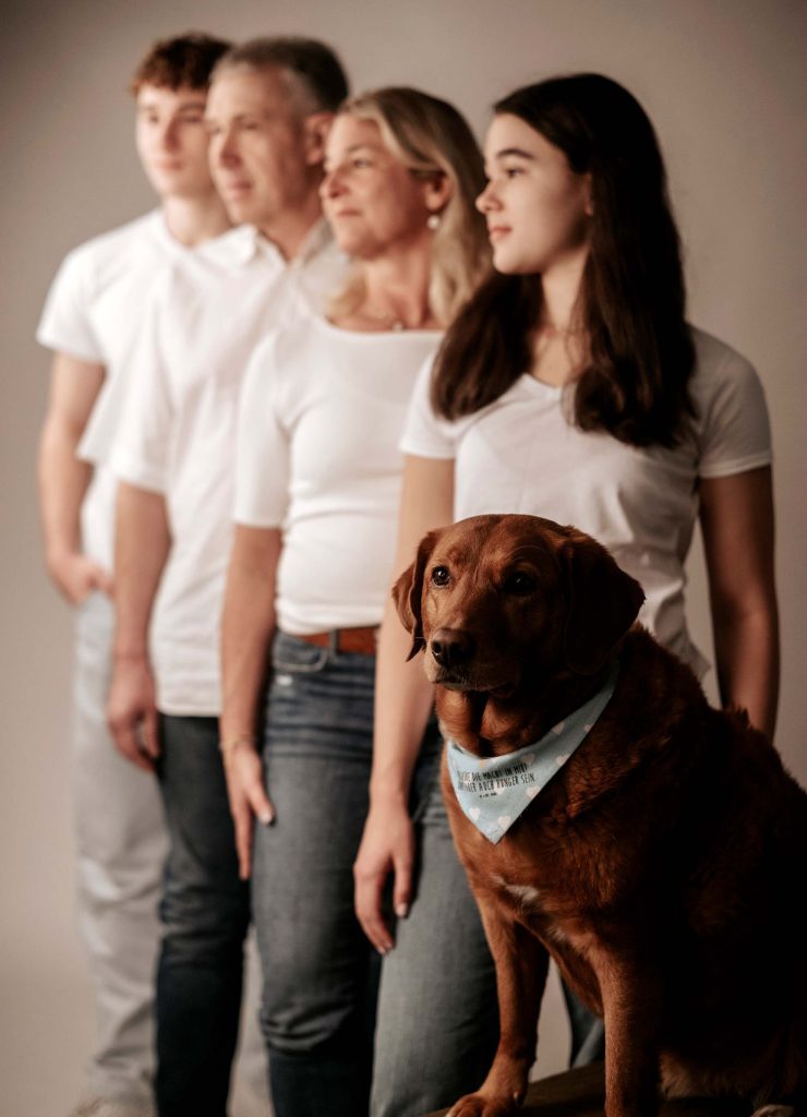 Authentisches Familienportrait von Sarah Reuther, das eine Familie mit Hund während eines Familienshootings in Koblenz zeigt.