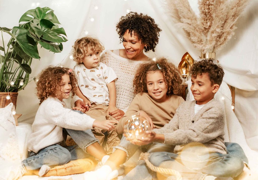 Festliches Familienportrait von Sarah Reuther, das eine Familie vor einem arrangierten Set aus Lichterketten während eines Familienshootings zeigt.
