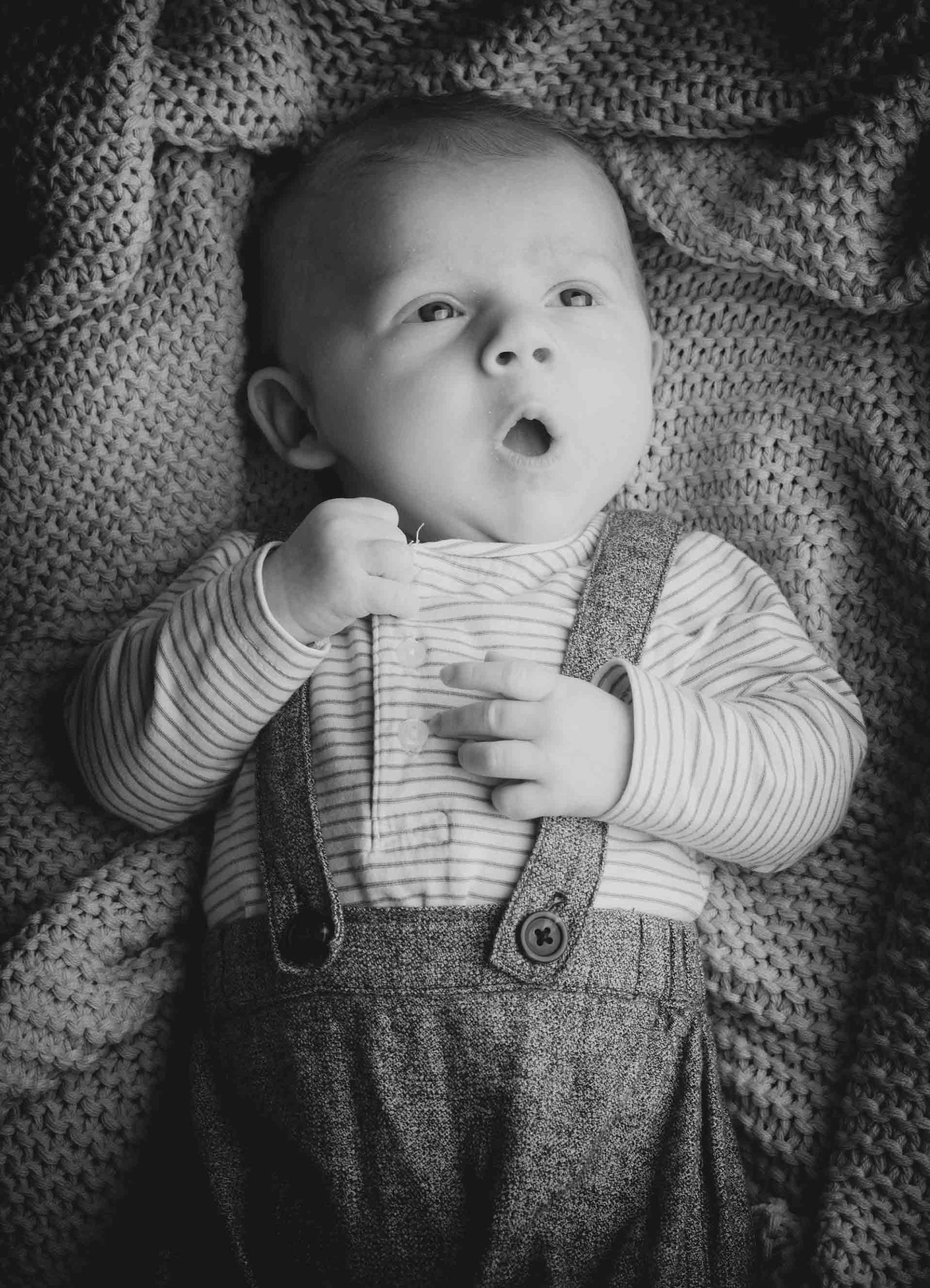 GNS (1) Portrait eines Babys, das in einer Decke gewickelt ist.