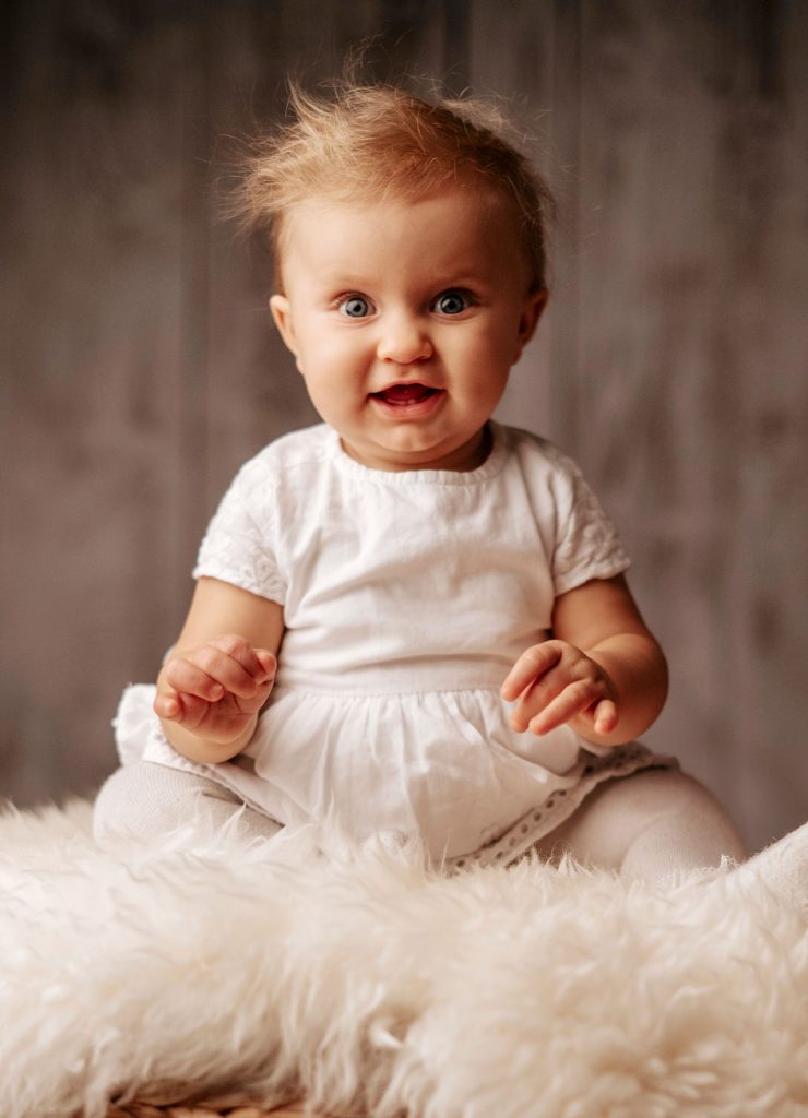 Portrait eines lachenden Babys, das in die Kamera schaut. Babyshooting - Schwangerschaftsfotografie von Fotostudio Reuther.