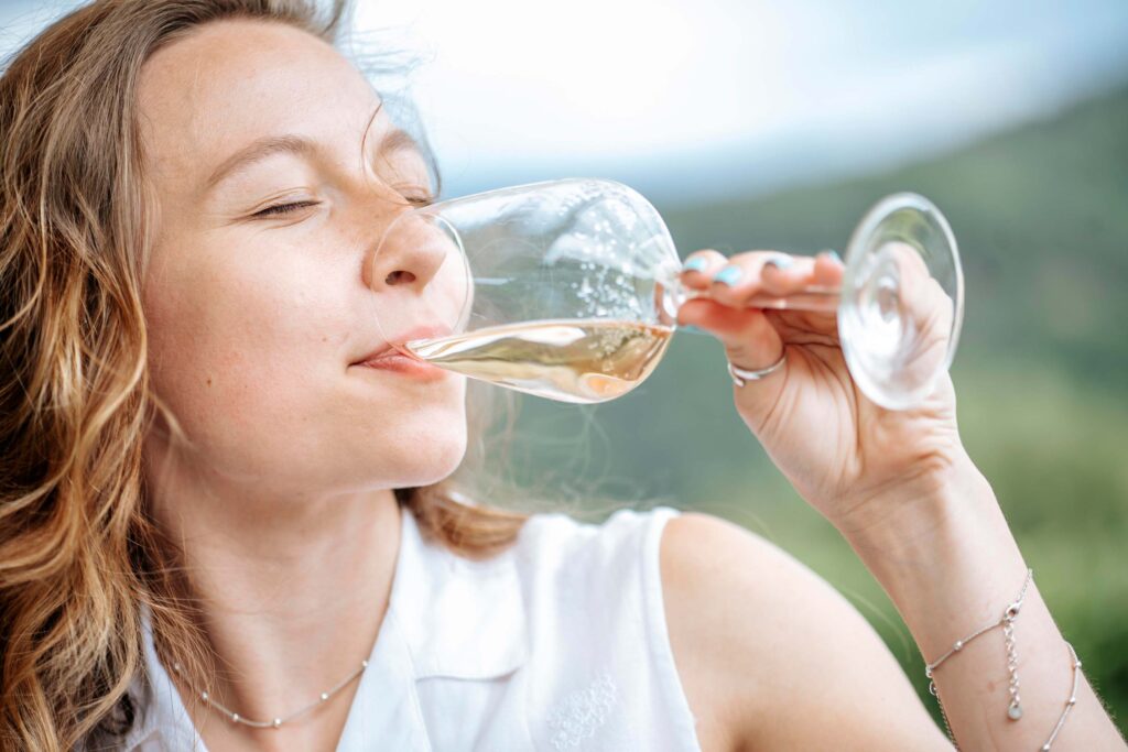 Eine Frau genießt ein Glas Wein, fotografiert von Fotostudio Reuther.