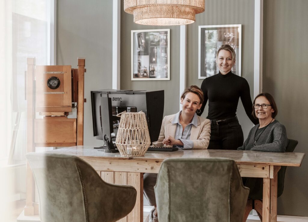 Das Team von Fotostudio Reuther, fotografiert im kreativen Eingangsbereich des Fotostudios.