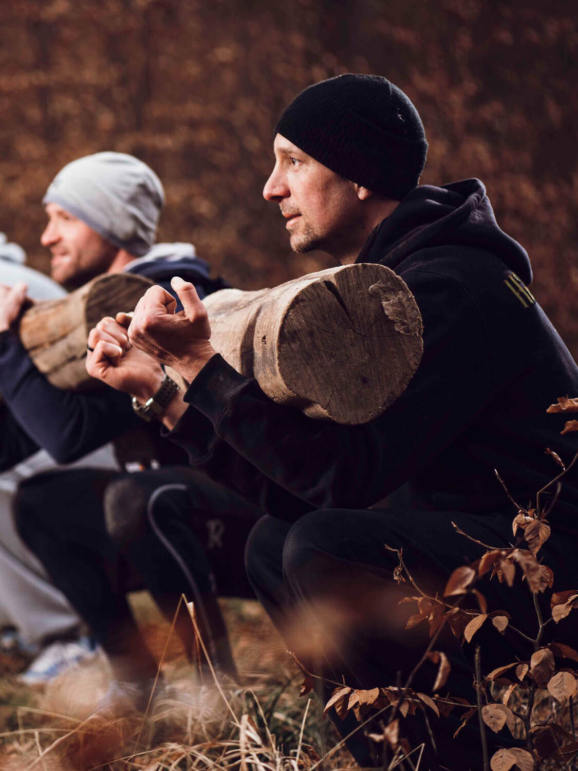 Ein paar Männer, die im Wald Sport treiben, die Dynamik und Motivation in der Fitnessfotografie von Fotostudio Reuther zeigen.