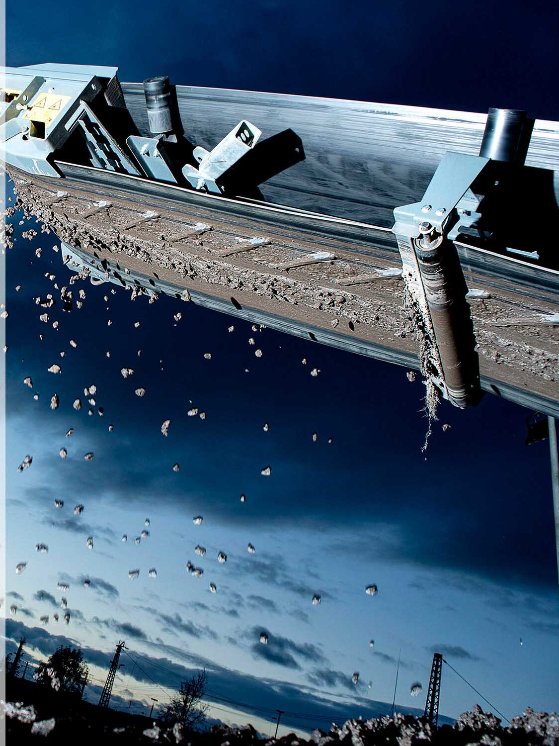 Förderband einer großen Maschine in der Dämmerung, das industrielle Prozesse und Effizienz in der Industriefotografie von Fotostudio Reuther darstellt.