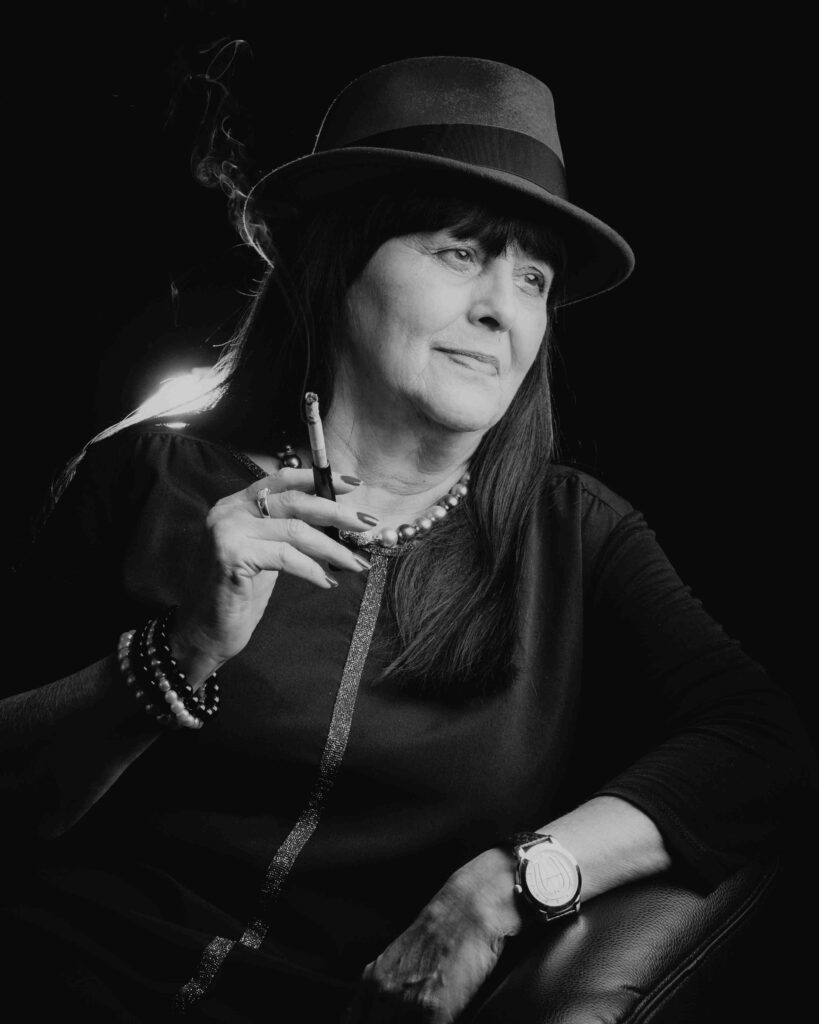 Stilvolles Schwarz-Weiß-Portrait einer Frau mit Hut und Zigarette von Sarah Reuther, ideal für moderne Portraitfotografie.